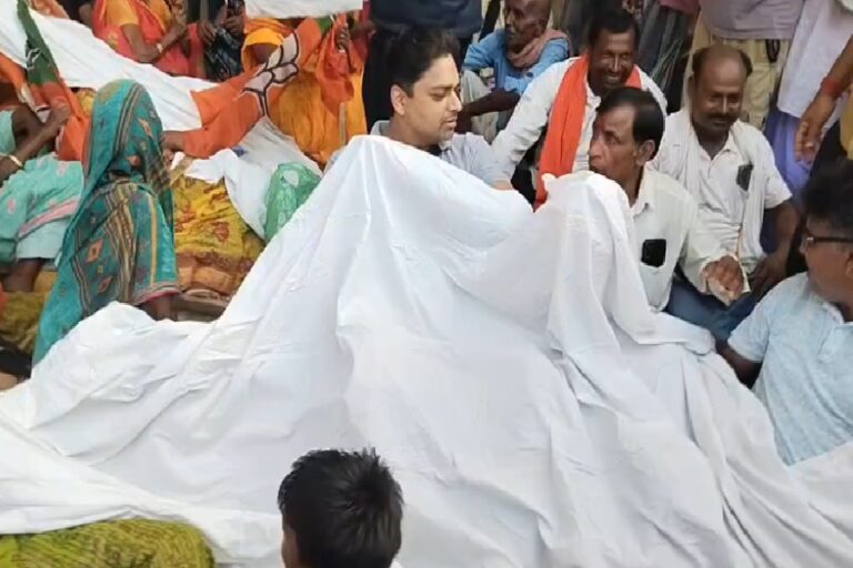 गोड्डा : पेंशन में देरी और पत्रकार को धमकी के विरोध में अमित मंडल का प्रदर्शन, कफन पहनकर धरने पर बैठे
